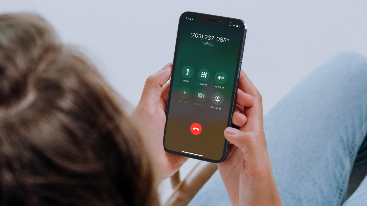 A person holding a cell phone calling Doorways' 24-hour hotline number, 703-237-0881.