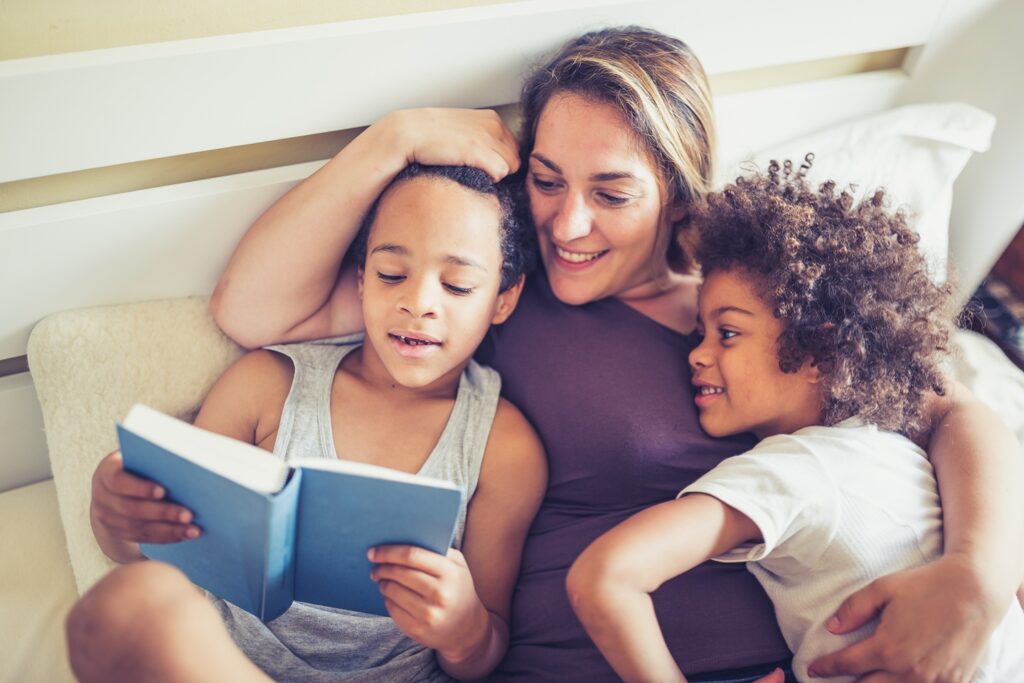 Melany and her children read a book together at bedtime