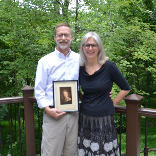 The Moaks pose in their backyard with a portrait of Evelyn