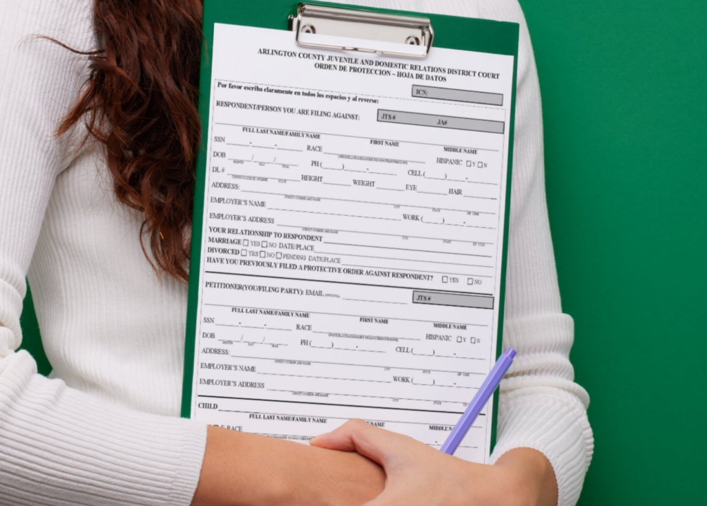 Person holding a clipboard with an Arlington County Juvenile and Domestic Relations District Court Protective Order Intake Sheet on it.
