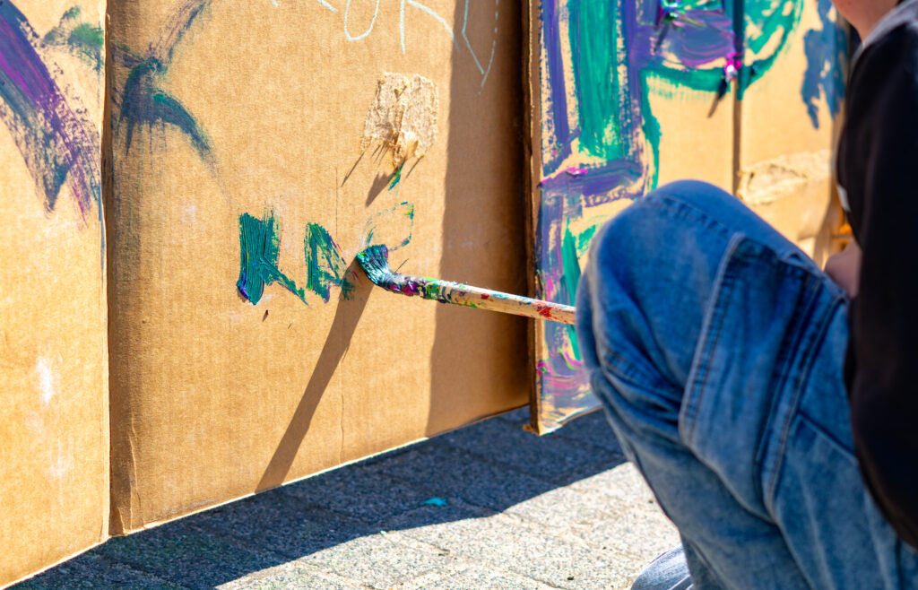 Daniel paints the cardboard that will become his rocketship